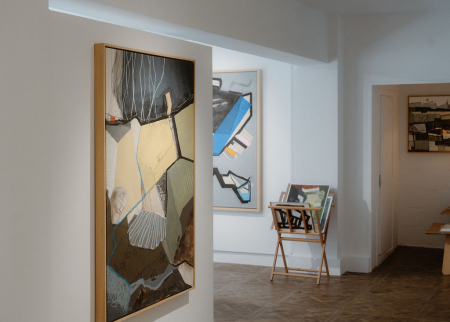 A large abstract painting and framed works in the white gallery.