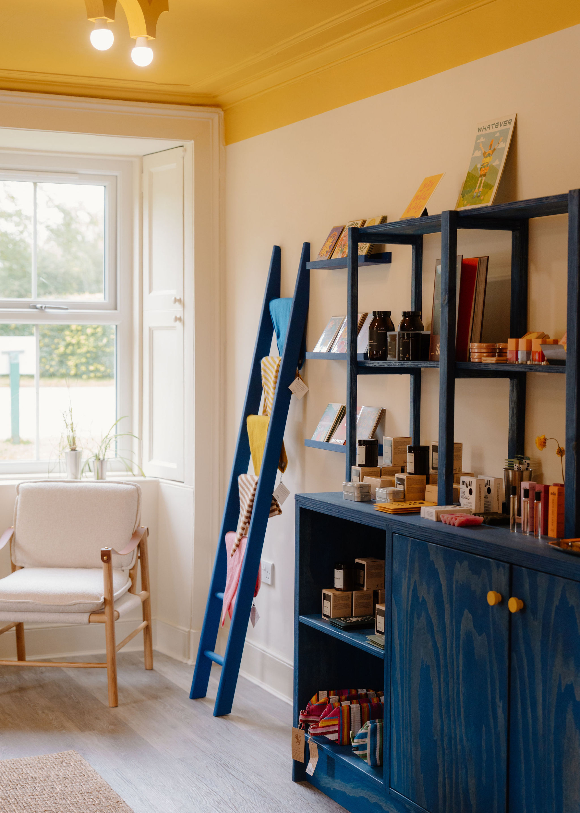 Yolk General Store's bright room, a blue dresser by a white window under a yellow ceiling.